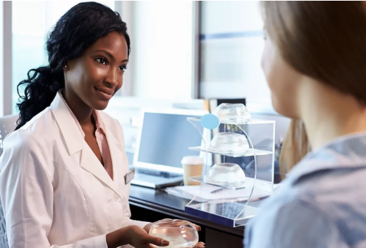 A professional woman in a white lab coat discussing the DeKalb ORB Project with a colleague.