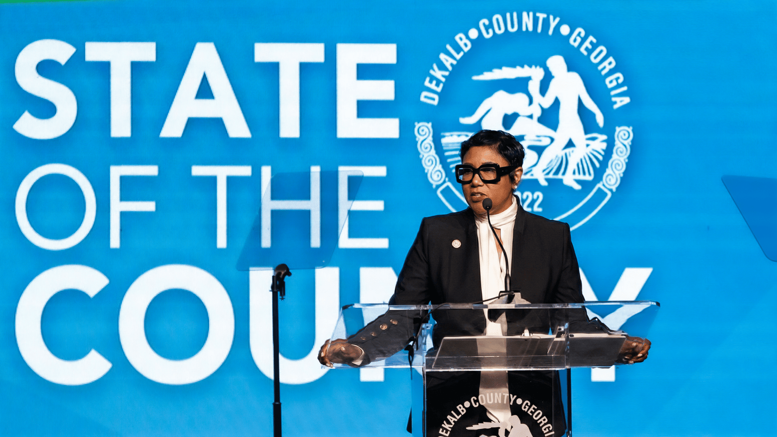 Lorraine Cochran-Johnson speaking at a "State of the County" event podium.